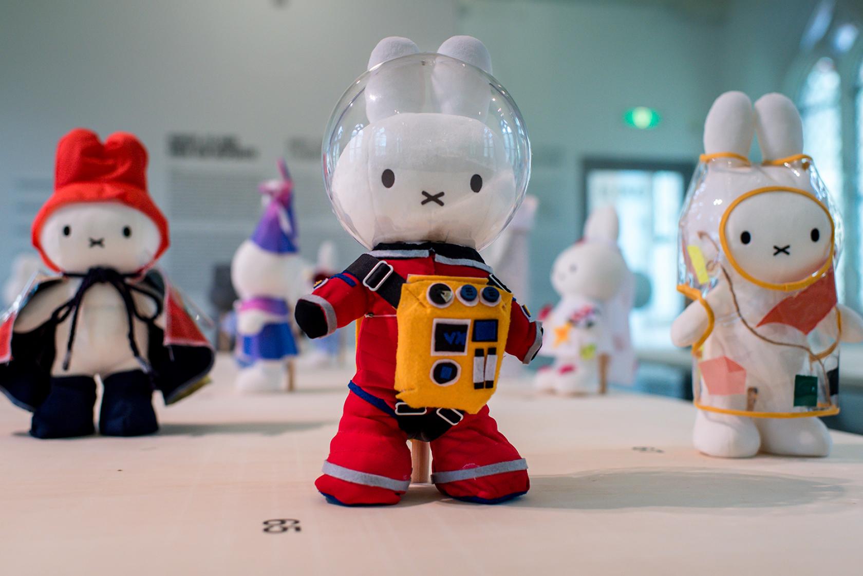 Foto van Nijntje in verschillende outfits tijdens een tentoonstelling.