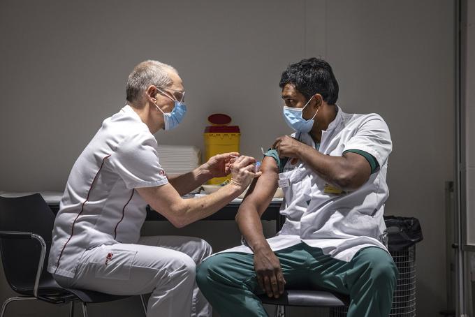 Een IC-medewerker van Amsterdam UMC wordt gevaccineerd tegen het coronavirus met het Pfizer biontech vaccin. ANP / Hollandse Hoogte / Ramon van Flymen