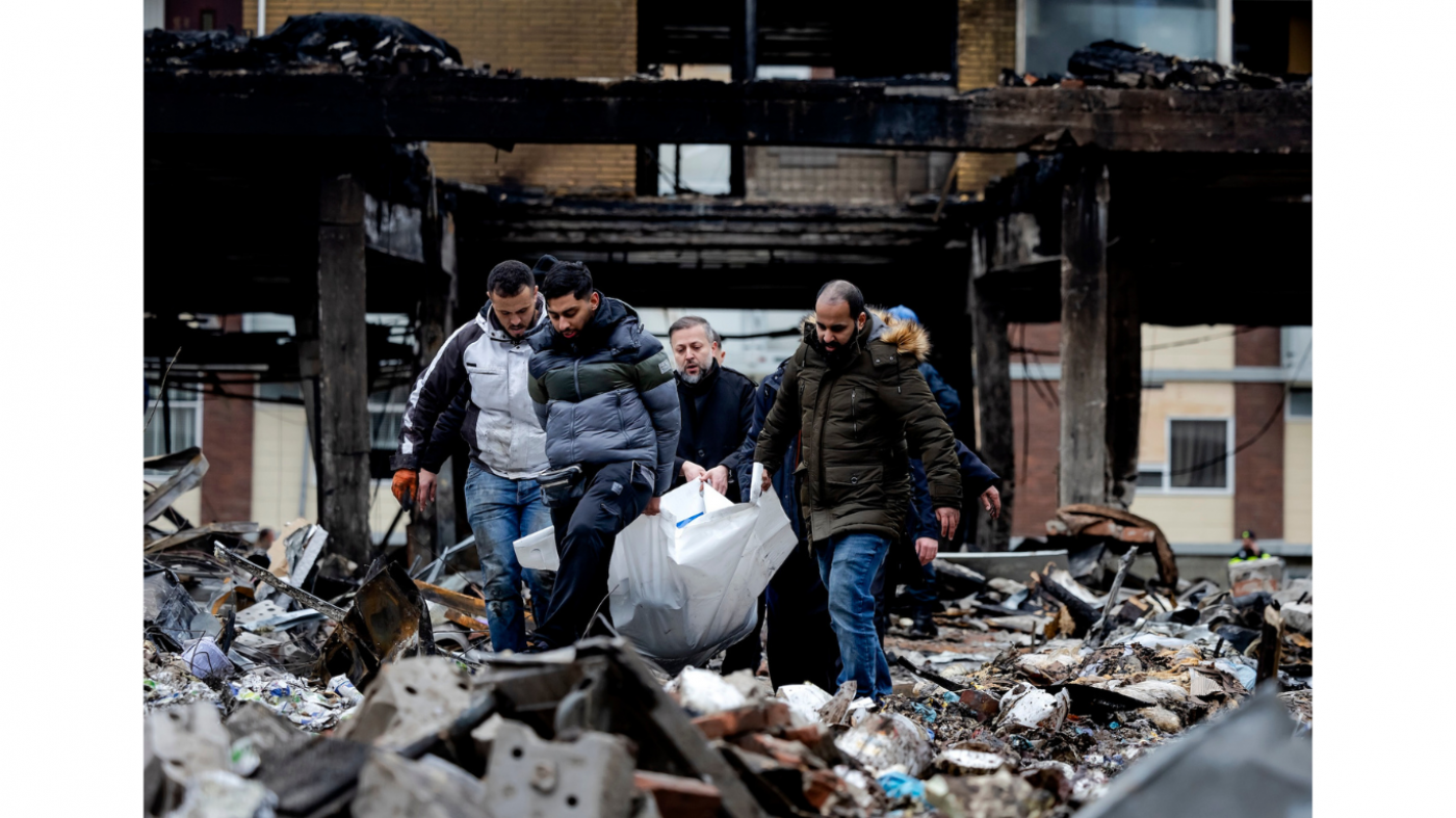 Een lichaam wordt door familieleden geborgen. Foto: ANP / Robin van Lonkhuijsen