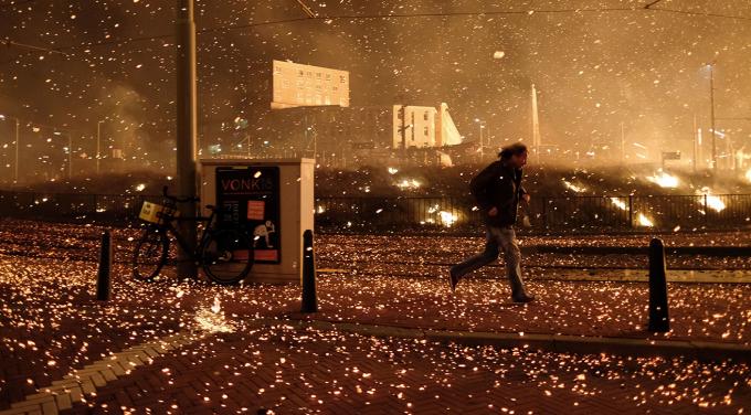 Scheveningen, 1 januari 2019 - De vonken van het vreugdevuur waaien de verkeerde kant op, wat voor schade en brandgevaar zorgt. Foto: Eric Brinkhorst